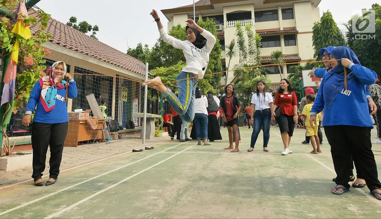 Seorang anak bermain permainan tradisional lompat tali di RPTRA Melati Duri Pulo, Jakarta, Sabtu (13/10). Traditional Games Returns (TGR) mengampanyekan permainan tradisional Indonesia untuk membangkitkan eksistensinya. (Liputan6.com/Herman Zakharia)
