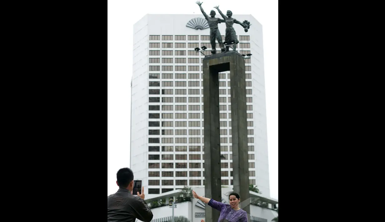 Seorang ibu dan anak sedang bergaya di dekat Bundaran Hotel Indonesia (HI), Jakarta, Kamis (1/1/2015). (Liputan6.com/Faizal Fanani)