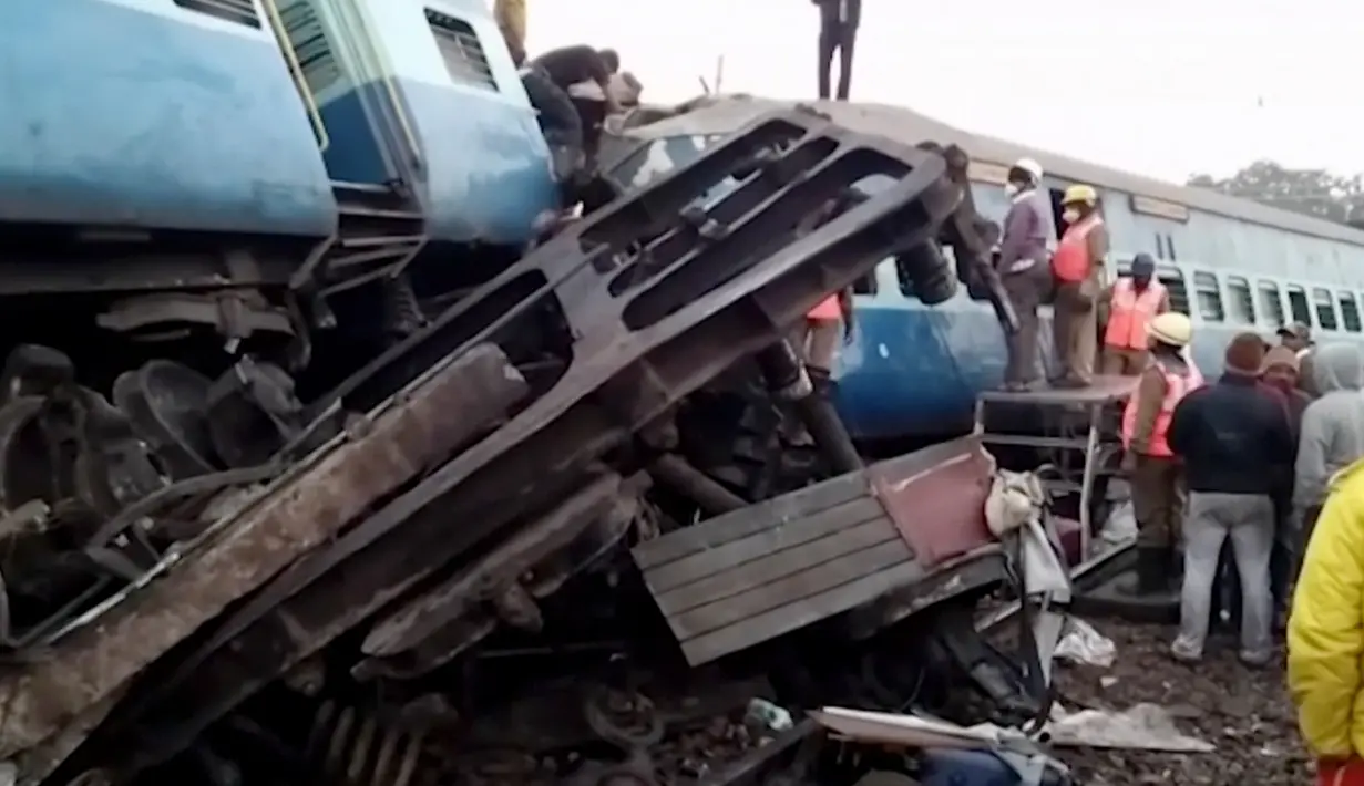 Warga melihat gerbong kereta api yang tergelincir di Andhra Pradesh, India, Minggu (22/1). Sebanyak tujuh gerbong penumpang dan mesin kereta tersebut keluar jalur di dekat Stasiun Kuneru di distrik Vizianagaram. (AP Photo)