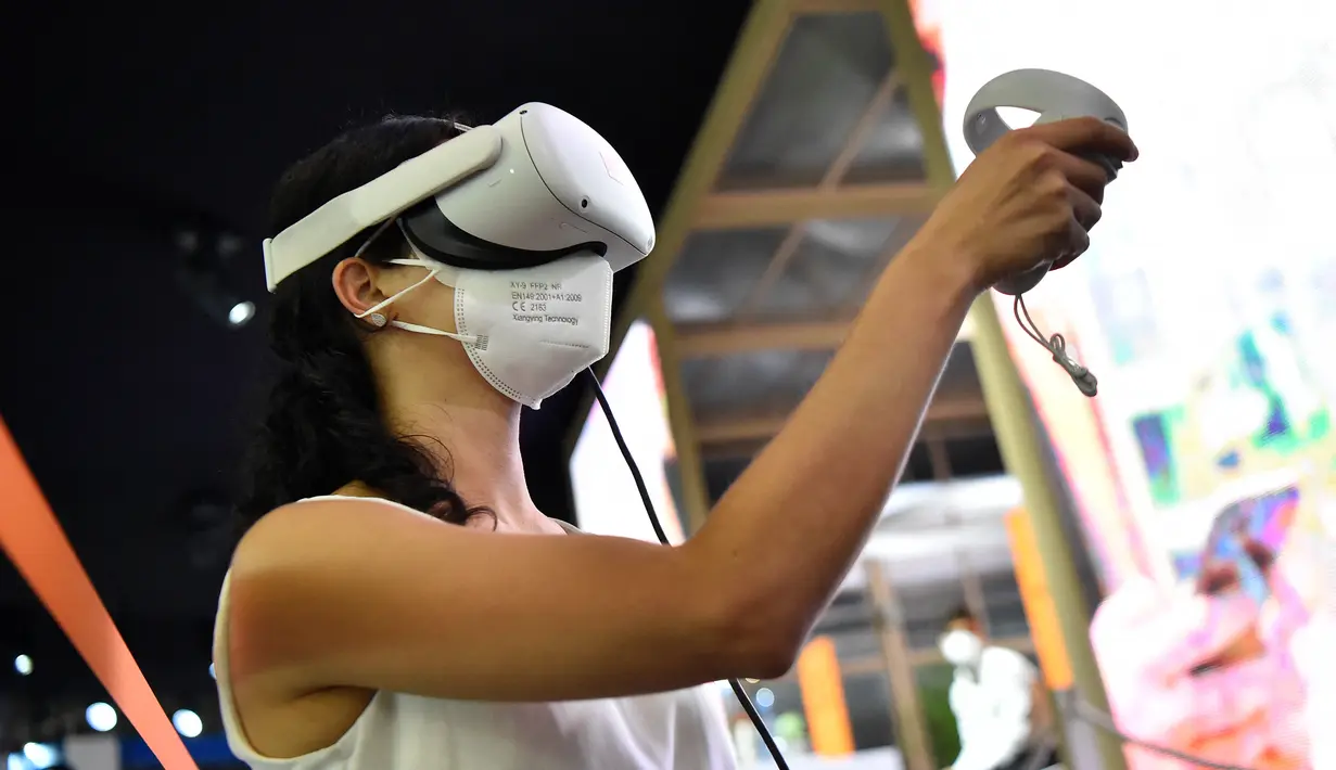 Seorang wanita mencoba kacamata virtual reality di stan Orange selama pameran Mobile World Congress (MWC) di Barcelona (28/6/2021). (AFP/Pau Barrena)