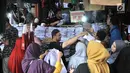 Pedagang melayani para orangtua yang mencari seragam sekolah di Pasar Jatinegara, Jakarta, Minggu (14/7/2019). Jelang tahun ajaran baru, Pasar Jatinegara ramai didatangi para orangtua yang mencari seragam sekolah untuk anaknya. (merdeka.com/Iqbal Nugroho)