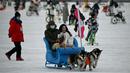 Orang-orang naik kereta luncur di Danau Houhai yang dingin pada hari bersalju di Beijing pada 20 Januari 2022. Ibu Kota China diselimuti salju pada Kamis, saat hitungan mundur menuju dua minggu Olimpiade Musim Dingin Beijing 2022 dimulai. (Noel Celis / AFP)