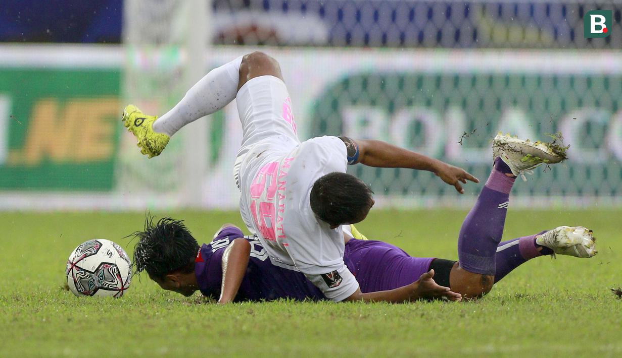 Pemain Persikabo 1973, Manahati Lestusen (atas) terjatuh setelah berduel dengan pemain Persik Kediri, Taufiq dalam lanjutan pertandingan babak penyisihan Grup D Piala Presiden 2022 di Stadion Kanjuruhan, Malang, Jawa Timur, Minggu (12/6/2022). (Bola.com/Arief Bagus)