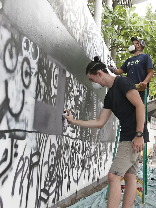 Siswa sedang melukis mural di dinding sekolah Jakarta Intercultural School (JIS), Jakarta, Sabtu (7/4). Kolaborasi antara darbortz dan siswa dilaksanakan dengan tujuan agar siswa memiliki pengalaman langsung berinteraksi. (Liputan6.com/Herman Zakharia)