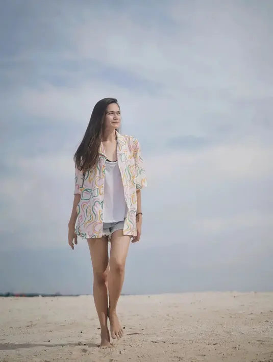Ketika liburan di pantai, ia tampil dengan gaya santai. Pemilik nama lengkap Sabai Dieter Morscheck ini memadukan atasan kemeja motif abstrak dengan kaus putih dan hot pants.(Liputan6.com/IG/@sabaidieter)