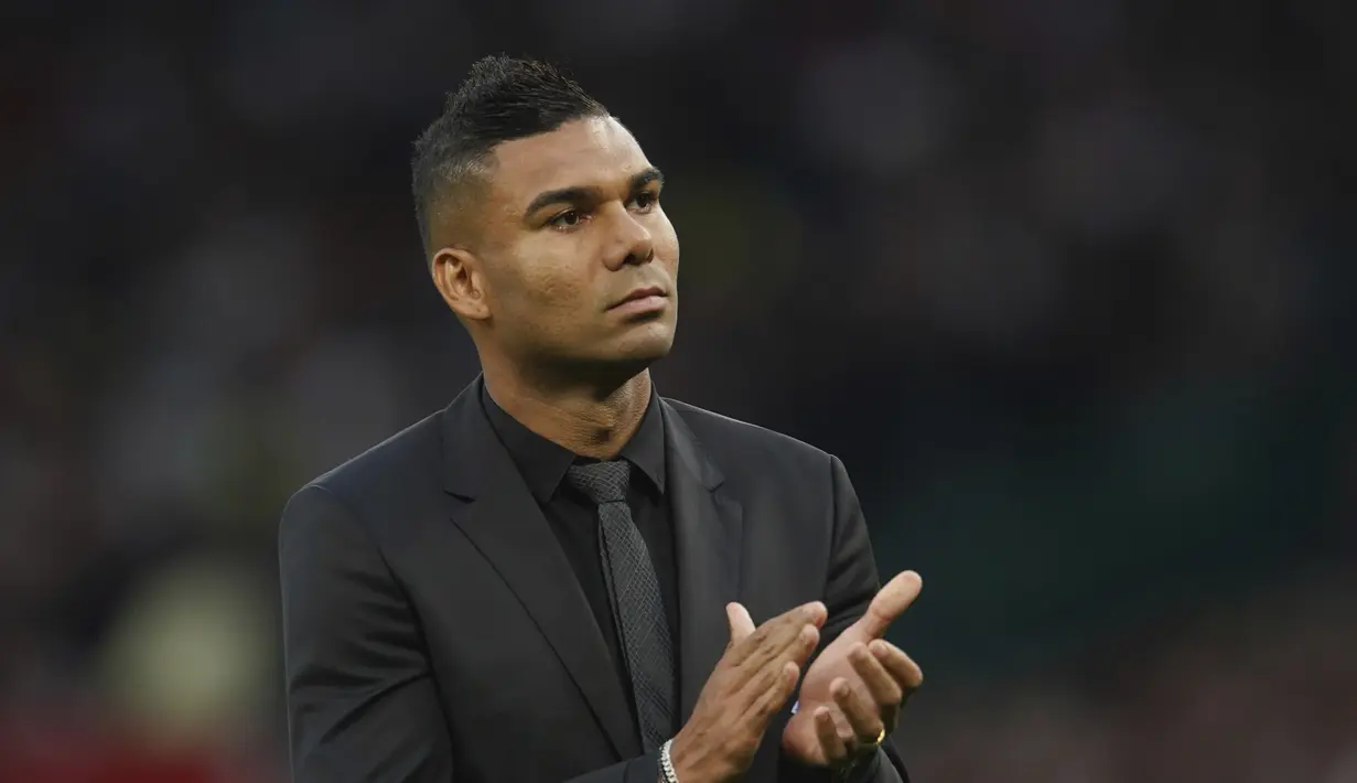 Pemain baru Manchester United Casemiro memberi tepuk tangan kepada para pendukung ketika diperkenalkan secara resmi sesaat sebelum laga MU vs Liverpool dimulai di stadion Old Trafford, Senin (22/8/2022). Casemiro pun duduk di tribun penonton, menyaksikan laga Man United vs Liverpool. (AP Photo/Dave Thompson)
