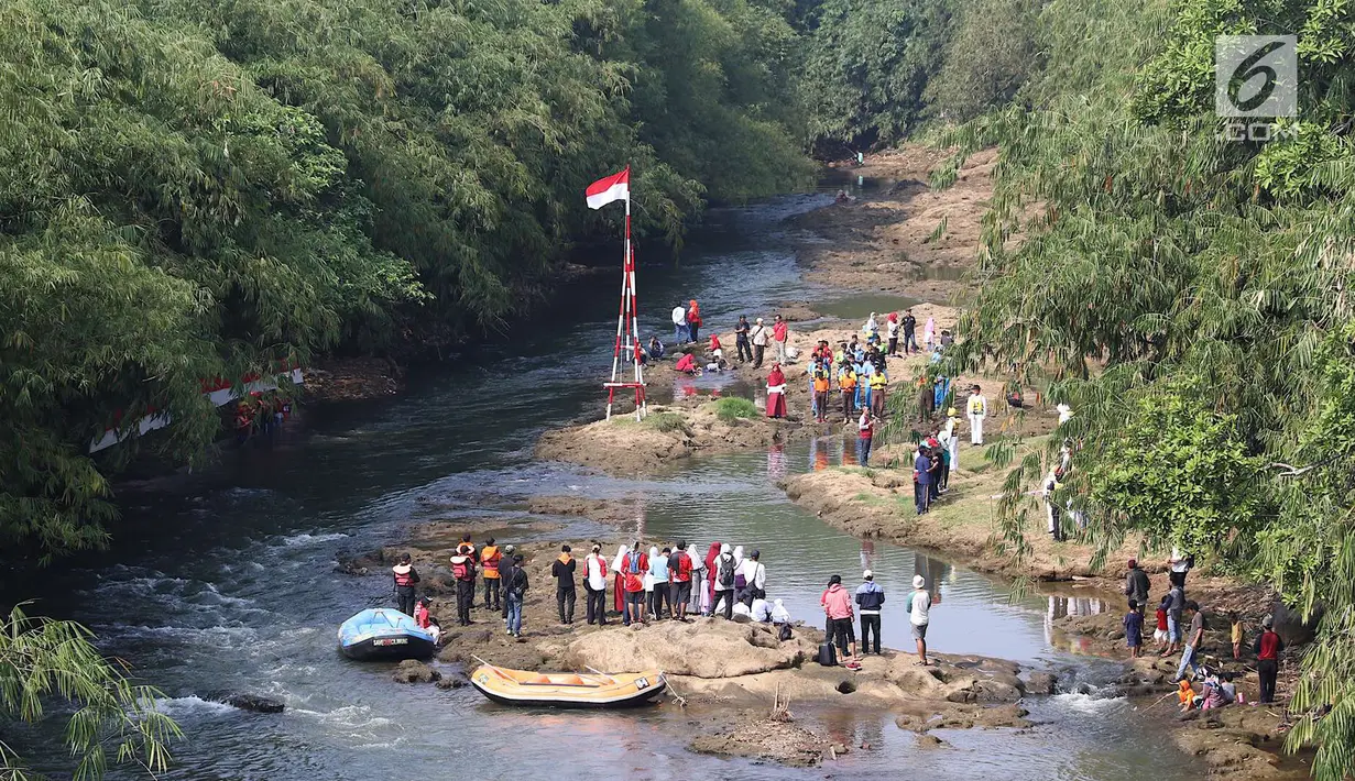 Komunitas Ciliwung Depok mengikuti upacara bendera di Sungai Ciliwung, Jawa Barat, Jumat (17/8). Upacara di tengah aliran Sungai Ciliwung tersebut dalam rangka memperingati HUT ke-73 Republik Indonesia. (Liputan6.com/Immanuel Antonius)