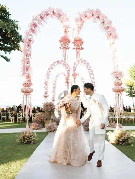 Adinia Wirasti memilih gaun pengantin warna dusty pink rancangan Mel Ahyar saat resepsi di Bali. Gaun ini kian spesial berkat detail sulaman yang intricate. [Instagram/venemapictures]