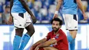 Penggawa Liverpool, Mohamed Salah duduk di atas lapangan melihat pemain Napoli, Kalidou Koulibaly pada matchday pertama Grup E Liga Champions di Stadion San Paolo, Selasa (17/9/2019). Juara bertahan Liverpool secara mengejutkan menyerah dua gol tanpa balas dari Napoli. (AP Photo/Gregorio Borgia)