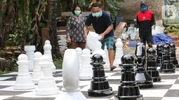 Warga bermain catur raksasa sambil menunggu waktu berbuka puasa di Pondok Betung, Tangerang Selatan, Kamis (14/5/2020). Tinggi bidak catur 50-86 cm dengan diameter sekitar 35 cm terbuat dari bahan viber glass dengan luas lapangan 4,8m x 4,8m. (Liputan6.com/Fery Pradolo)