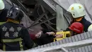 Petugas penyelamat mengevakuasi seorang korban di gedung apertemen yang runtuh akibat gempa 6,4 SR  di Tainan, (6/2). Menurut data meteorologi gempa terjadi pada kedalaman 16,7 kilometer di bawah permukaan laut. (REUTERS/Stringer)