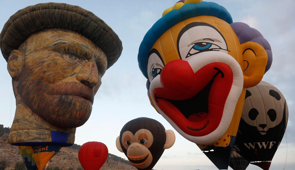 Sejumlah balon mengudara saat Festival Balon Udara Gilboa di dekat Kibbutz Ein Harod, Lembah Jizreel, Israel (4/8). Balon udara panas yang menghiasi Lembah Jizreel beraneka karakter, seperti badut, wajah seniman dan lain-lain. (AFP Photo/Manahem Kahana)