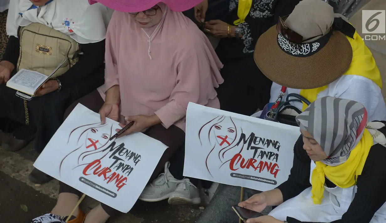 Massa aksi membawa poster untuk menggelar aksi kawal putusan hasil sengketa pilpres 2019 di sekitar Gedung Mahkamah Konstitusi (MK), Jakarta, Kamis (27/6/2019). Para demonstran yang turun ke jalan hanya duduk di sekitaran kawasan Patung Kuda yang telah ditutup oleh petugas. (merdeka.com/Imam Buhori)