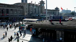 Orang-orang tiba di stasiun kereta api Beijing pada hari terakhir libur nasional "golden week" pada Kamis (7/10/2021). Hari libur selama 8 hari pada 1-7 Oktober tersebut menjadi hari libur terbesar kedua di Cina setelah tahun  baru. (JADE GAO / AFP)