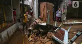 Warga membersihkan sisa lumpur yang tertinggal di permukiman mereka yang ada di sekitar jalan layang Kalibata-Cililitan, Jakarta, Rabu (5/3/2025). (Liputan6.com/Angga Yuniar)