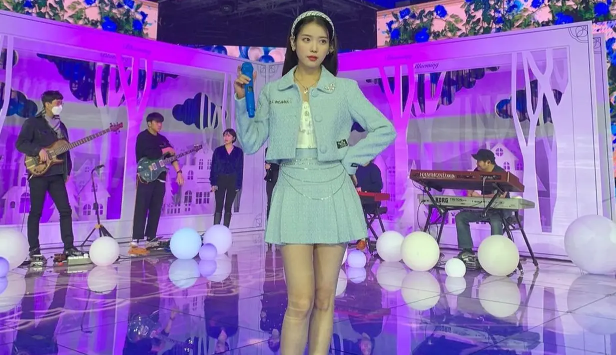 Di sini, IU tampil mengenakan set blazer dan skirt dengan head accessory berwarna biru muda yang senada. IU juga memilih boot putih tinggi untuk membuat tubuhnya terkesan lebih tinggi. Foto: Instagram @dlwlrma.