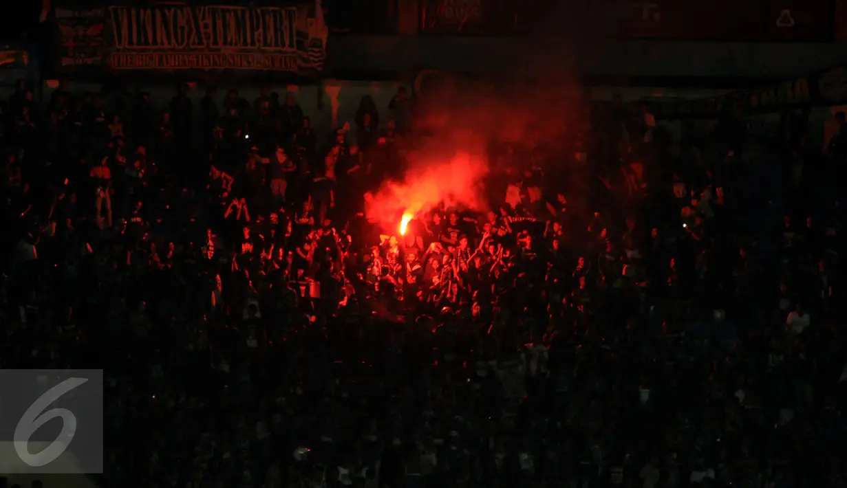 Suporter Persib menyalakan flare usai menyaksikan laga Persib kontra PBFC di lanjutan Turnamen Piala Bhayangkara di Stadion Si Jalak Harupat, Bandung, Minggu (20/3/2016). Persib unggul 1-0 atas PBFC. (Liputan6.com/Helmi Fithriansyah)