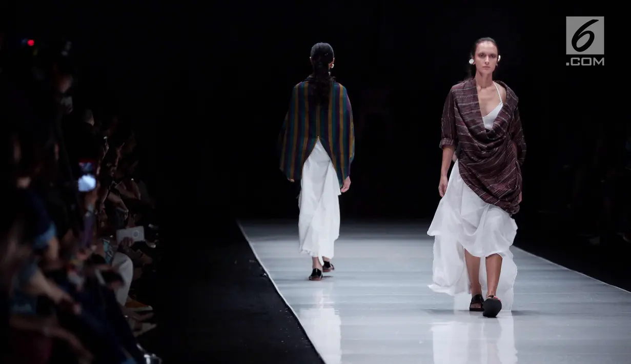 Model berjalan diatas catwalk mengenakan busana rancangan Lulu Lutfi Labibi dalam ajang Jakarta Fashion Week 2018 di Senayan City, Jakarta, Kamis (26/10). Lulu menampilkan rancangannya dengan mengusung tema 'Persimpangan'. (Liputan6.com/Faizal Fanani)