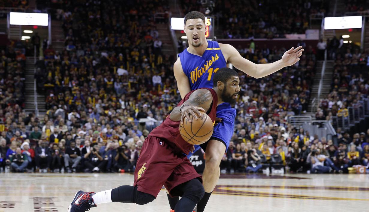 Pemain Cleveland Cavaliers, Kyrie Irving (2) menggiring bola melewati kawalan pemain Warriors, Klay Thompson (11) pada laga NBA di Quicken Loans Arena, (25/12/2016). Cleveland menang 109-108. (Reuters/Brian Spurlock-USA TODAY Sports)