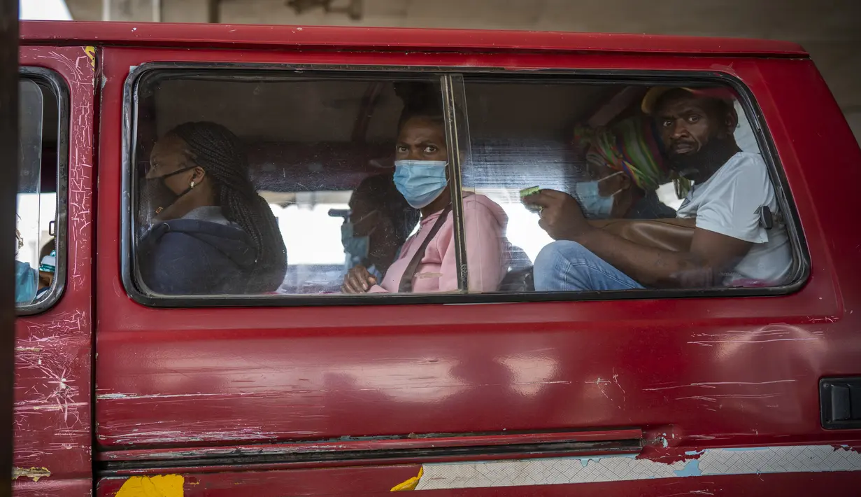 Penumpang, beberapa memakai masker, menunggu taksi mereka meninggalkan pangkalan taksi Baragwanath di Soweto, Kamis (2/12/2021). Afrika Selatan mempercepat kampanye vaksinasi untuk memerangi lonjakan pesat kasus Covid-19 usai mendeteksi varian Omicron pekan lalu. (AP Photo/Jerome Delay)