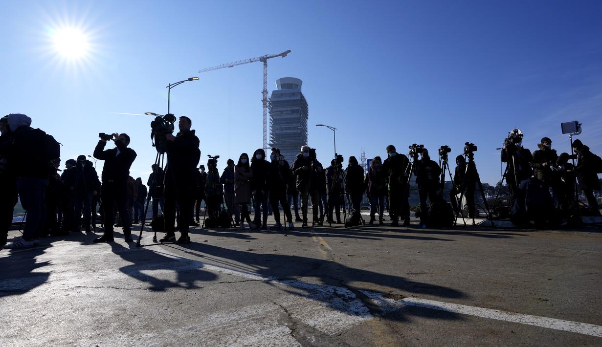 Jurnalis menunggu di luar terminal VIP di bandara Nikola Tesla di Beograd, Serbia, Senin (17/1/2022). Petenis nomor satu dunia Novak Djokovic diperkirakan akan tiba di ibu kota Serbia setelah dideportasi dari Australia pada hari Minggu terkait status vaksinasinya (AP Photo/Darko Vojinovic)