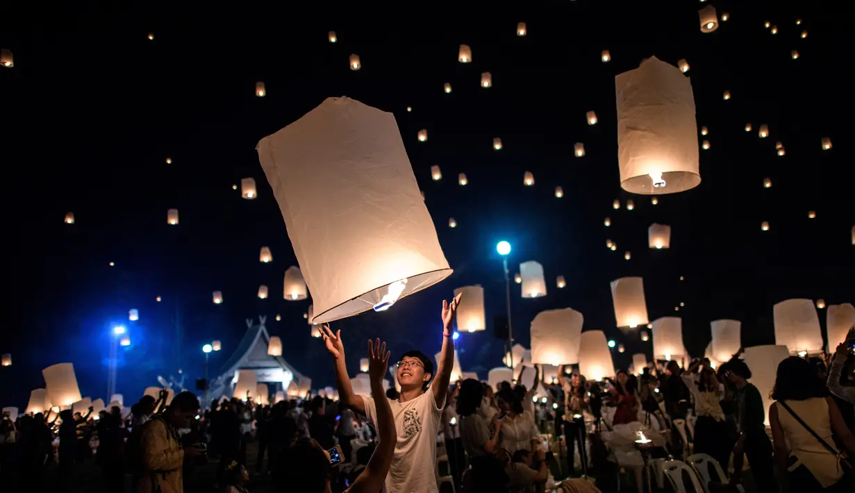 Remaja melepaskan lampion ke udara saat perayaan festival Yee Peng di Chiang Mai (3/11). Acara ini ternyata juga sebagai salah satu festival yang bersifat religius bagi masyarakat Budha. (AFP Photo/Roberto Schmidt)