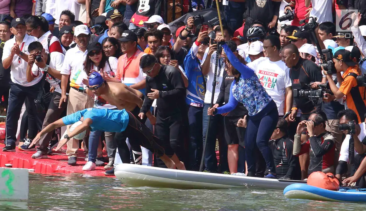 Menteri Kelautan dan Perikanan Susi Pudjiastuti dan Wakil Gubernur DKI Jakarta Sandiaga Uno saat bertanding melintasi danau sepanjang 1k selama Festival Danau Sunter di Jakarta, Minggu (25/2). (Liputan6.com/Angga Yuniar)