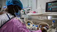 Seorang ibu di Uganda, Namukwaya, memeriksa bayi kembarnya di dalam inkubator di Rumah Sakit Internasional dan Pusat Kesuburan Wanita. (FOTO: AFP)