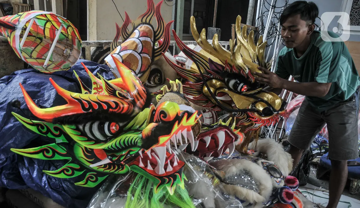 Pekerja saat menyelesaikan pembuatan Liong dan Barongsai di kawasan Babakan Pasar, Bogor, Jawa Barat, Senin (17/1/2022). Barongsai dibanderol dengan harga jual mulai Rp5 juta per buah sementara liong dihargai mulai Rp8 juta per buah. (merdeka.com/Iqbal S Nugroho)