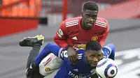 Bek Manchester United, Axel Tuanzebe (atas) berebut bola dengan striker Leicester City, kelechi Iheanacho dalam laga lanjutan Liga Inggris 2020/2021 pekan ke-35 di Old Traffod Stadium, Manchester, Selasa (11/5/2021). Manchester United kalah 1-2 dari Leicester. (AP/Peter Powell/Pool)