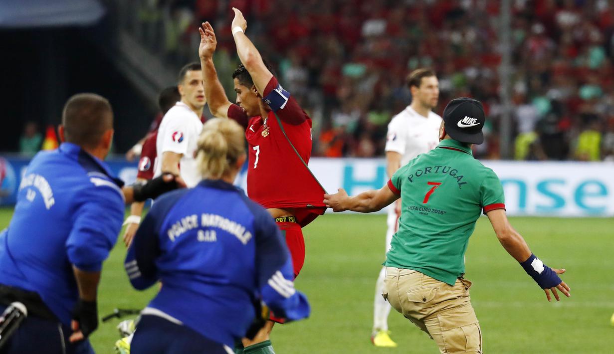 Seorang suporter nekat memasuki lapangan untuk memeluk Cristiano Ronaldo saat Portugal melawan Polandia pada perempat final Piala Eropa 2016 di Stade Velodrome, Marseille, (1/7/2016) dini hari WIB. (REUTERS/Kai Pfaffenbach)