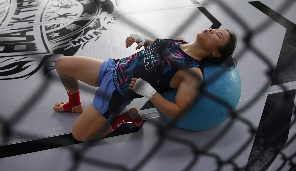 Petarung MMA China Zhang Weili melakukan pemanasan selama latihan di gym di Beijing (7/8/2019). Zhang bisa menjadi juara dunia UFC pertama asal China jika dapat mengalahkan pemegang gelar Jessica Andrade dari Brasil dalam pertarungan kelas berat mereka pada 31 Agustus 2019. (AFP Photo/Greg Baker)