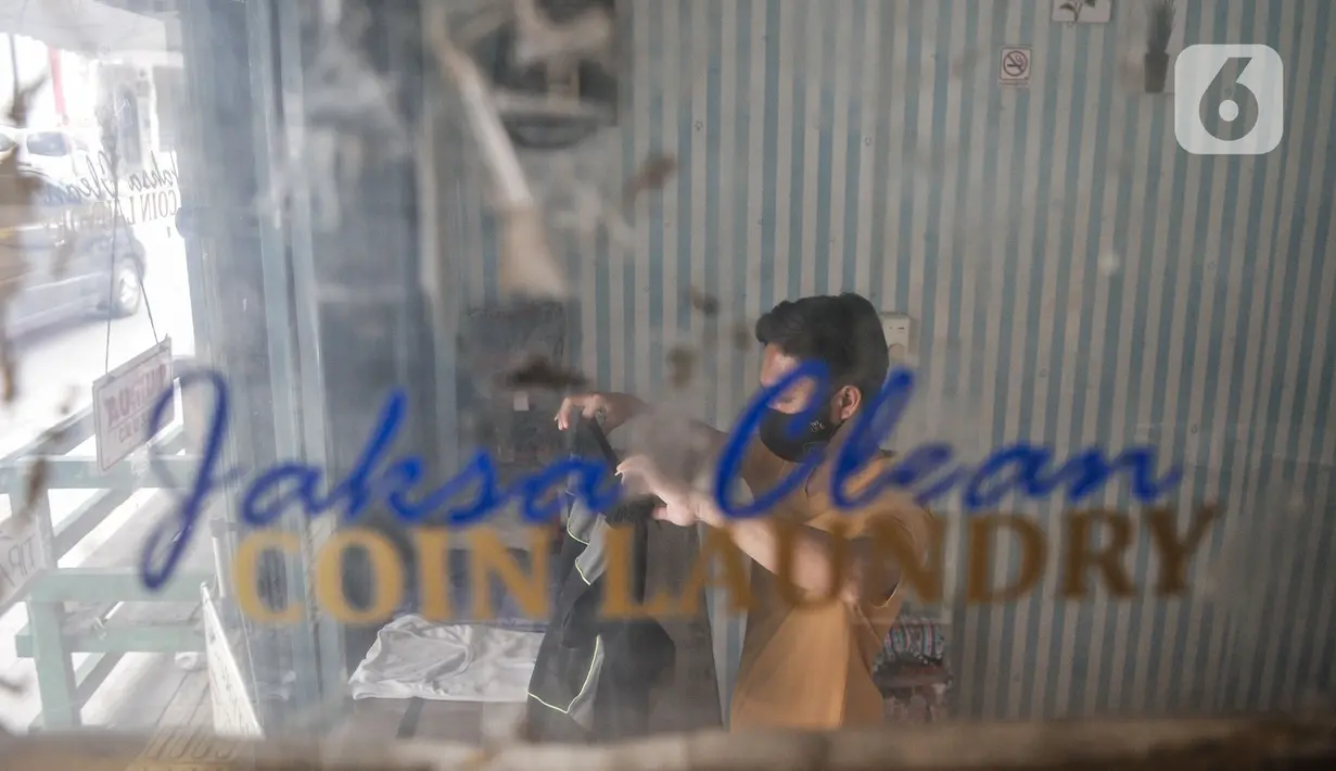 Pekerja merapikan pakaian pelanggan yang dititipkan di Jaksa Clean Coin Laundry, Jalan Jaksa, Jakarta, Kamis (1/4/2021). Seorang pekerja mengungkapkan sebelum pandemi biasanya menerima rata-rata 10 pelanggan dalam sehari, namun kini merosot menjadi 4 pelanggan per hari. (merdeka.com/Iqbal S Nugroho)
