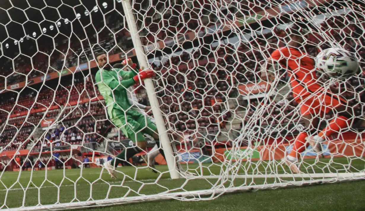 Kiper timnas Belanda, Ryan Gravenberch mencetak gol ketiga untuk timnya melewati kiper timnas Georgia, Giorgi Loria dalam pertandingan uji coba jelang Piala Eropa 2020 di De Grolsch Veste, Minggu (6/6/2021). Belanda menang meyakinkan 3-0. (AP Photo/Peter Dejong)