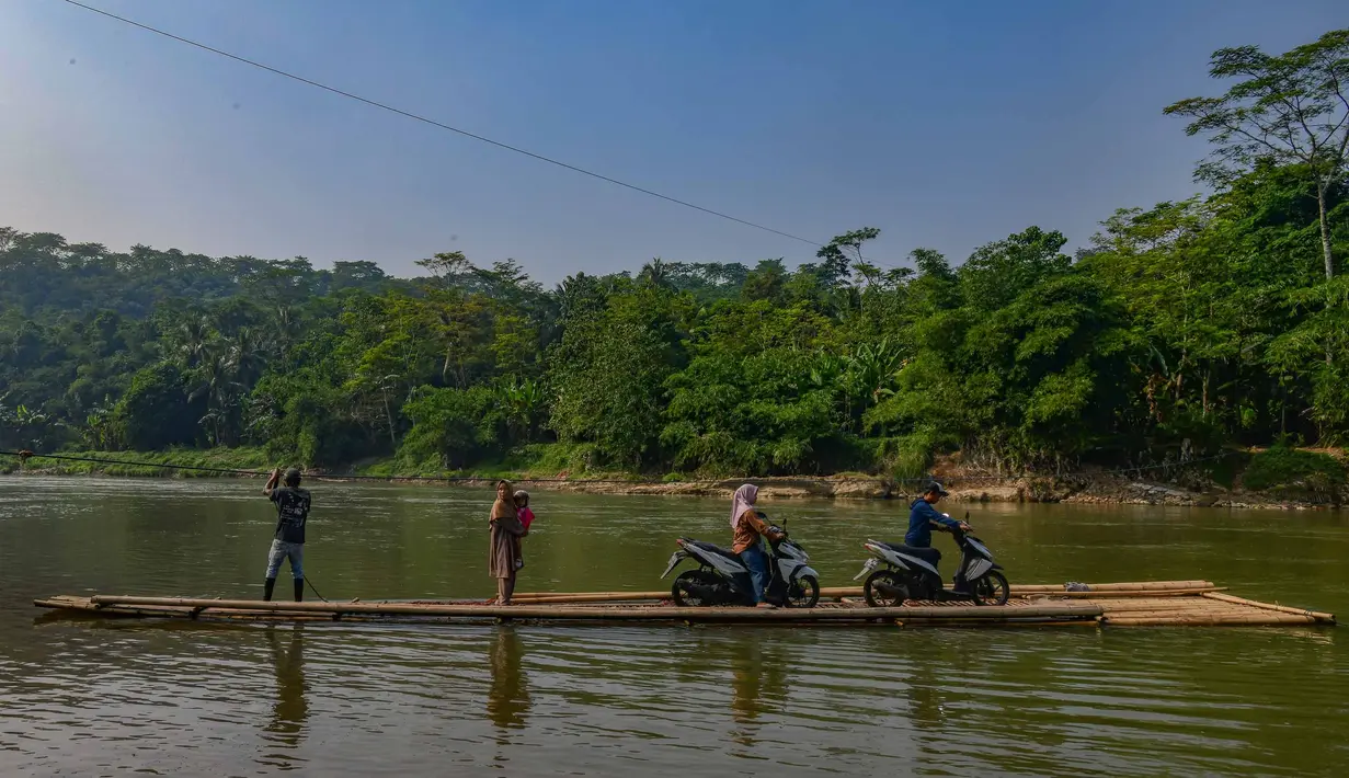 Warga bersama sepeda motornya menyeberangi Sungai Cisadane menggunakan rakit bambu di kawasan Ciseeng, Kabupaten Bogor, Jawa Barat, Kamis (11/6/2026). (merdeka.com/Arie Basuki)