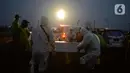 Petugas memakamkan jenazah korban Covid-19 di TPU Rorotan Cilincing, Jakarta, Sabtu (19/6/2021). Pemakaman jenazah dengan protokol covid-19 terus meningkatdalam satu pekan terakhir, seiring dengan lonjakan kasus corona di Ibu kota. (merdeka.com/Imam Buhori)