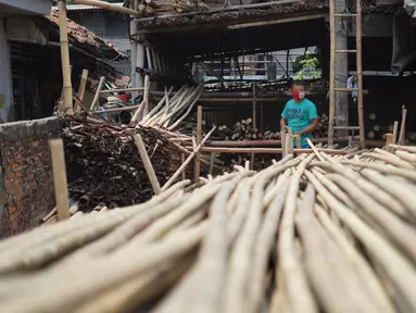 Perajin memilah bambu yang biasa digunakan sebagai tiang bendera di kawasan Manggarai, Jakarta, Kamis (6/8/2020). Adanya pandemi covid-19 menyebabkan penjualan bambu menurun hingga 35% dibanding tahun lalu. (Liputan6.com/Immanuel Antonius)