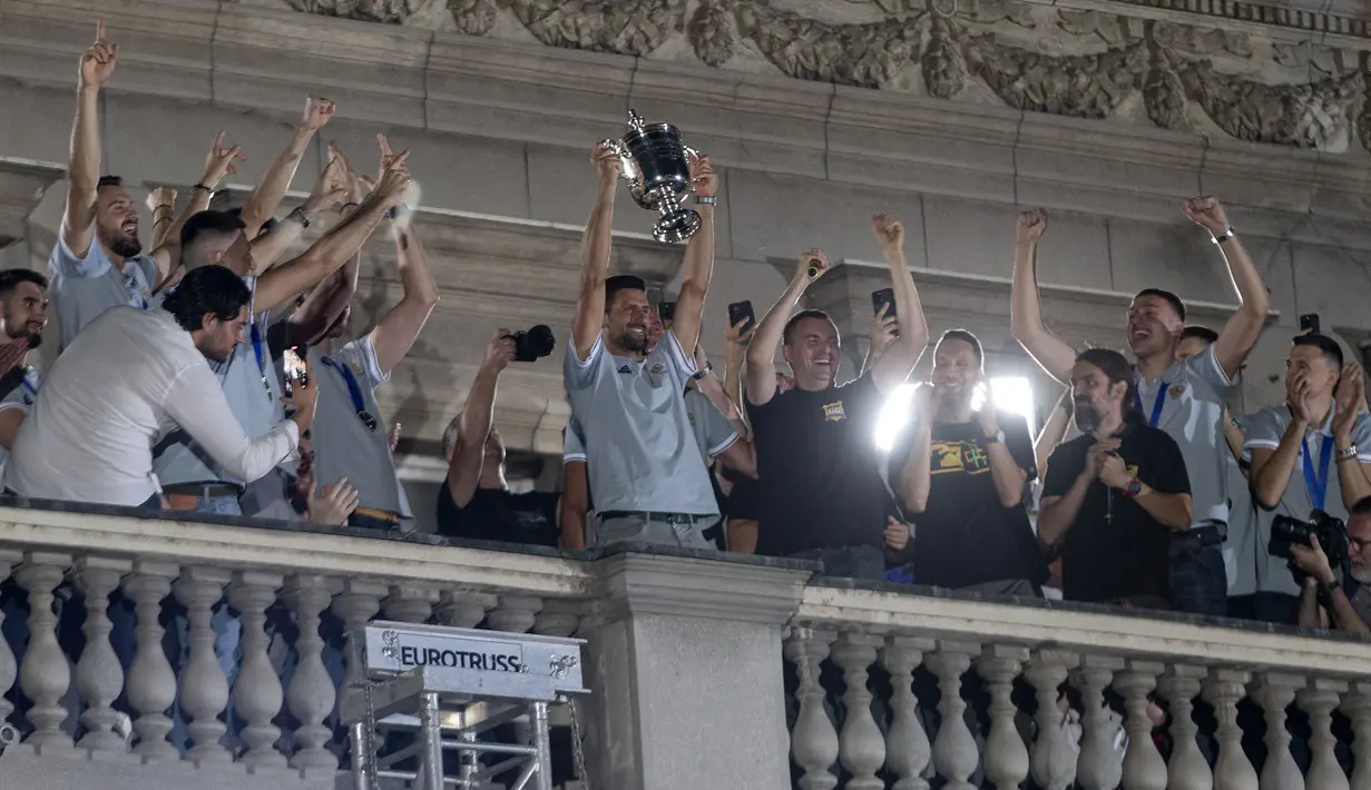 Petenis Serbia, Novak Djokovic (tengah) mengangkat trofi US Open 2023 saat acara penyambutan oleh masyarakat Serbia di ibu kota Belgrade, Serbia, 12 September 2023 waktu setempat. Djokovic berhasil memenangkan US Open 2023 setelah menumbangkan petenis Rusia, Daniil Medvedev dengan skor 6-3 7-6(5) 6-3 di partai final. (AFP/Dusan Milenkovic)