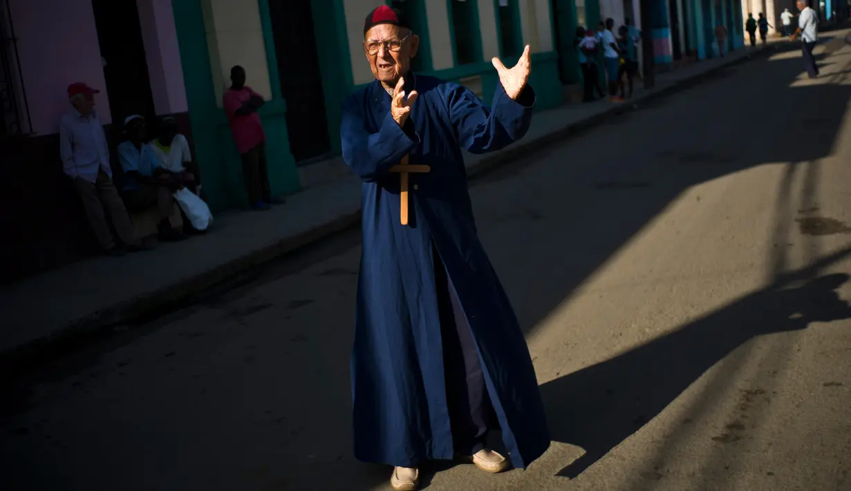 Seorang pria bernama Marcelino Rogelio Estrada berperan sebagai imam saat festival Burial of Pachencho di Santiago de Las Vegas, Kuba (5/2). Tradisi untuk menguburkan orang hidup-hidup ini dimulai sejak Februari 1984. (AP Photo/Ramon Espinosa)