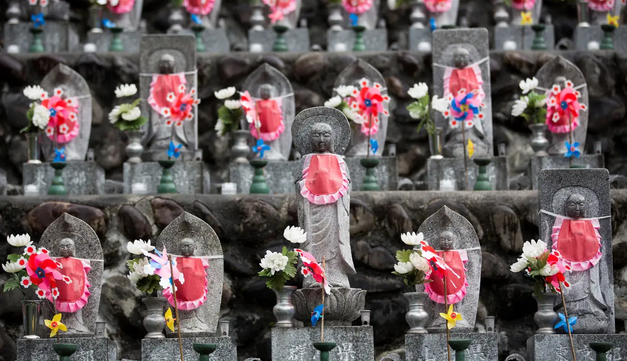 Deretan patung Jizo berdiri di Kuil Buddha Jizoji, Oganomachi, Prefektur Saitama, Jepang, Senin (13/8). Kuil Jizoji mengabadikan sekitar 15.000 patung batu jizo. (Behrouz Mehri/AFP)