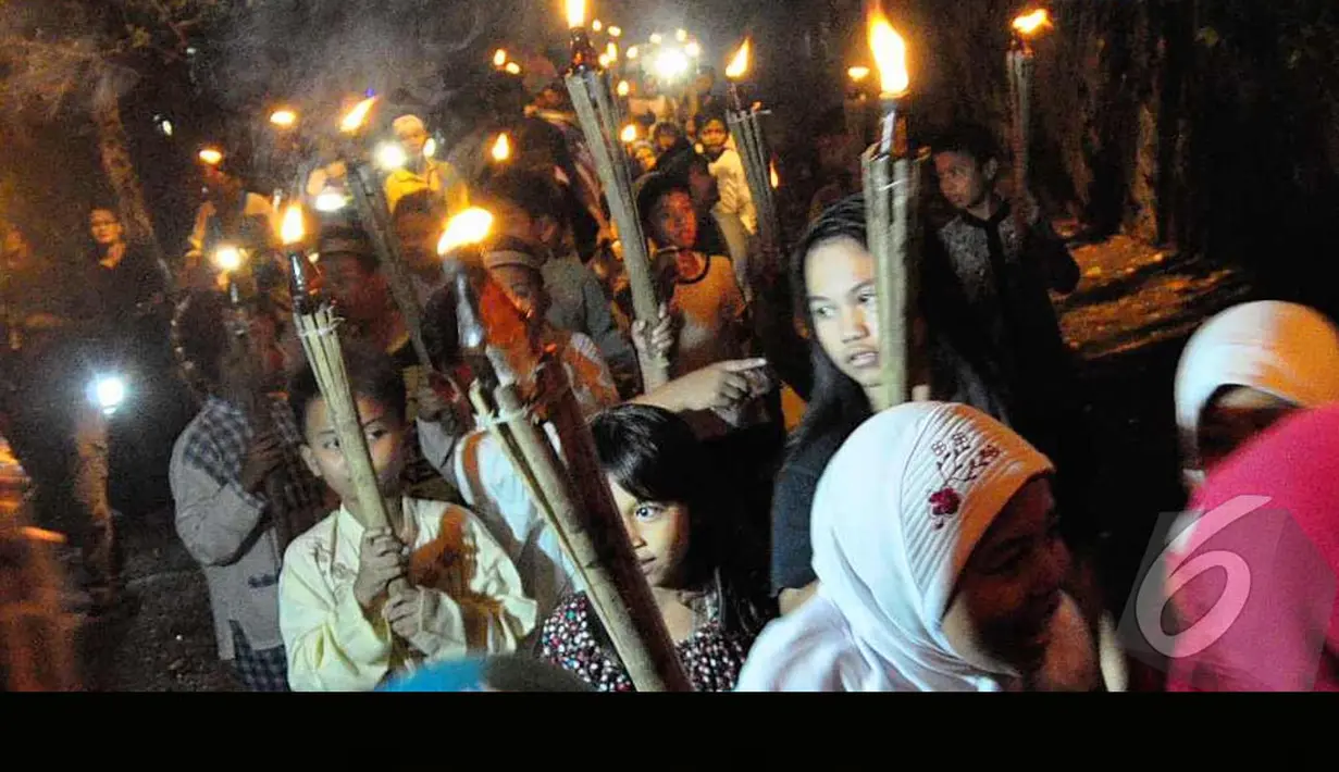 Para bocah membawa obor dan berkeliling kampung saat malam takbiran, Jakarta, Minggu (28/7/2014) (Liputan6.com/Faizal Fanani)