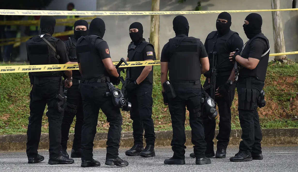 Aparat polisi bersenjata dengan menggunakan penutup wajah bersiaga di dalam Gedung Mahkamah Sepang, Kamis (13/4). Sidang terdakwa pembunuhan Kim jong-Nam, Siti Aisyah dan Doan Thi Huong di bawah penjagaan ketat aparat keamanan. (AP Photo/Vincent Thian)