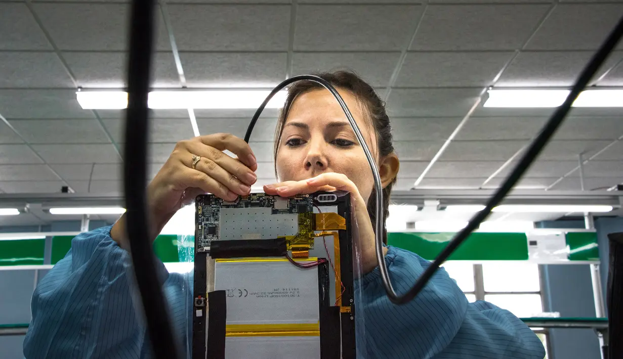 Teknisi wanita menyelesaikan proses perakitan tablet PC berteknologi Haier China di sebuah pabrik Industri Informatika, Komunikasi dan Elektronika Kuba (Gedeme), Havana, Kuba (15/5). (AFP Photo/Adalberto Roque)