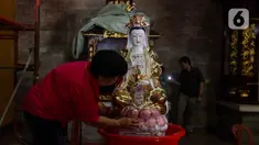 Warga membersihkan patung di Wihara Amurva Bhumi, Jakarta, Jumat (2/2/2024). (Liputan6.com/Herman Zakharia)