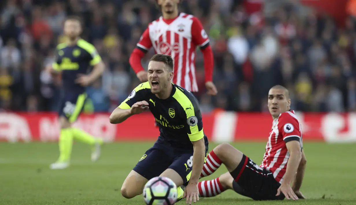 Pemain Southampton, Oriol Romeu (kanan) melakukan pelangaran terhadap pemain Arsenal, Aaron Ramsey pada laga Premier League di St Mary's stadium, Southampton, (10/5/2017). Arsenal menang 2-0. (AP/Alastair Grant)