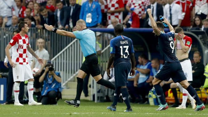 Wasit Nestor Pitana menunjuk titik penalti setelah mendapat arahan dari video assistant referee (VAR) pada final Piala Dunia 2018. (AP Photo/Petr David Josek)