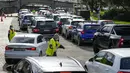 Petugas mengarahkan mobil di klinik pengujian COVID-19 drive-thru di Pantai Bondi di Sydney, Sabtu (8/1/2022). Negara bagian terpadat di Australia itu memberlakukan kembali beberapa pembatasan dan menangguhkan operasi elektif ketika kasus COVID-19 melonjak ke rekor baru lainnya (AP Photo/Mark Baker)