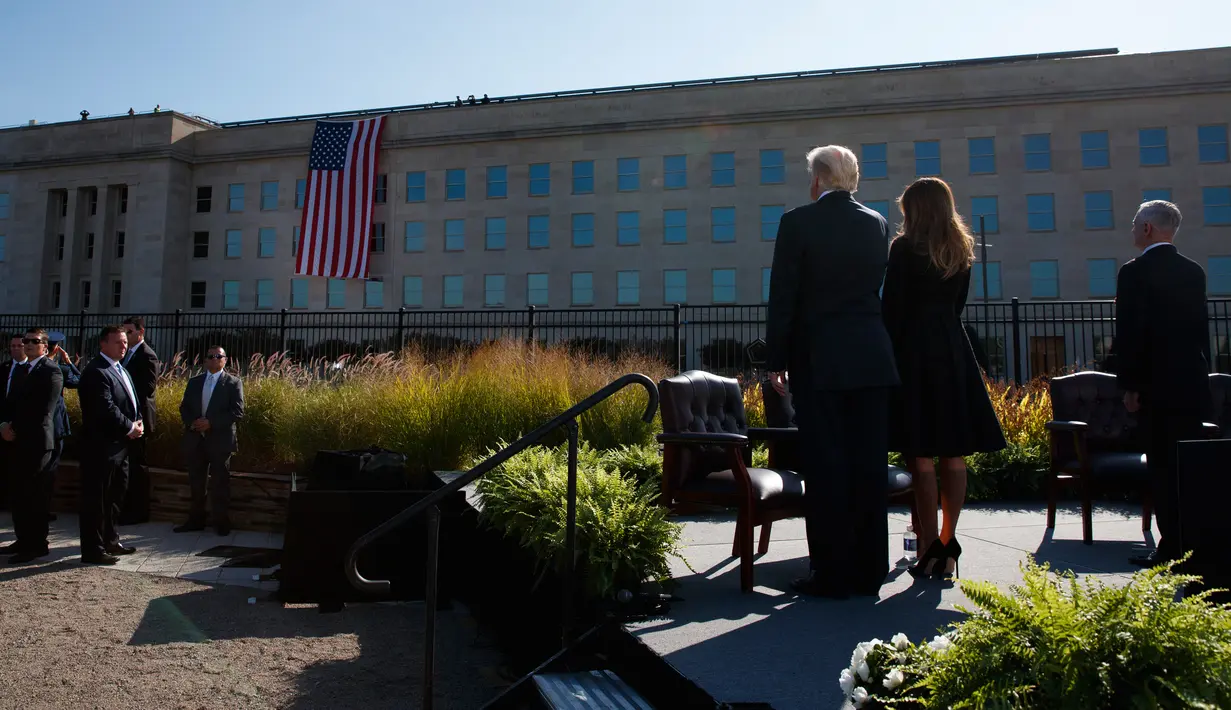 Presiden AS Donald Trump dan Ibu Negara, Melania Trump mengheningkan cipta untuk korban serangan 11 September 2001 dalam acara peringatan di Pentagon, Senin (11/9). Trump untuk pertama kalinya sebagai Presiden memimpin peringatan 9/11. (AP/Evan Vucci)