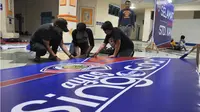 Media Officer dan Manajer Bisnis Arema Cronus turun tangan mempersiapkan acara pembukaan Piala Jenderal Sudirman. Mereka lembur sejak tiga hari yang lalu. (Bola.com/Kevin Setiawan)
