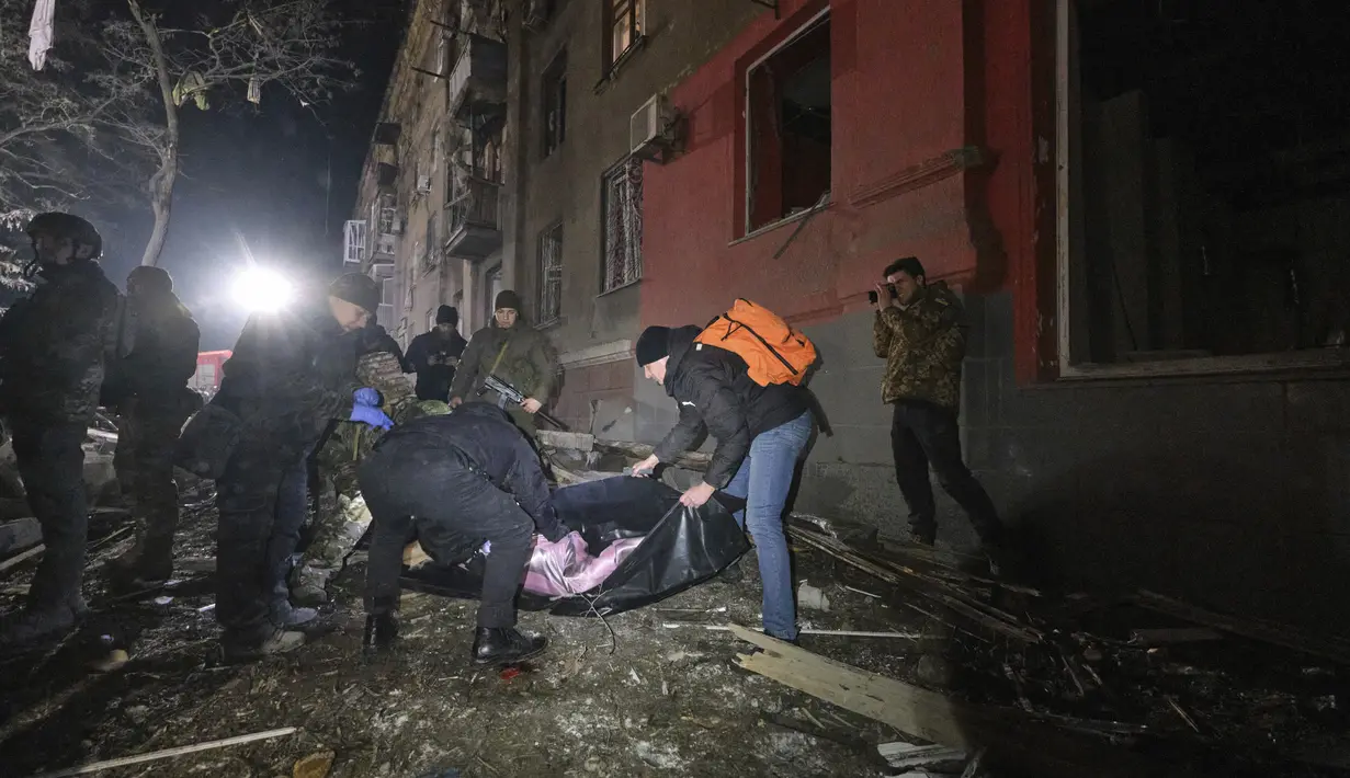 Petugas polisi memasukkan jenazah ke dalam kantong mayat setelah korban tewas akibat serangan roket Rusia di lingkungan perumahan di Kramatorsk, Ukraina, pada Kamis, 2 Februari 2023. Sedikitnya 3 orang tewas dan 21 luka-luka dalam serangan itu. (Foto AP/Yevgen Honcharenko)